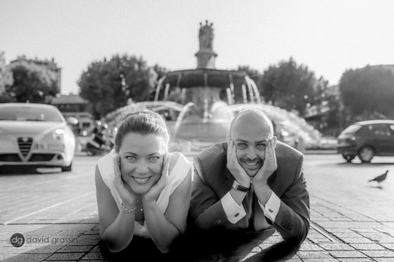 les mariés s'amusent pendant la séance de photo de couple. (ici ils sont allongés devant la fontaine de la rotonde)