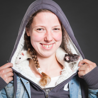 Pretty smiling girl with rats, in the studio.