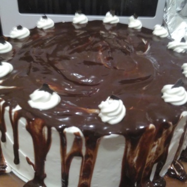 bolo com massa branca recheio de brigadeiro coberto com chantily e ganache