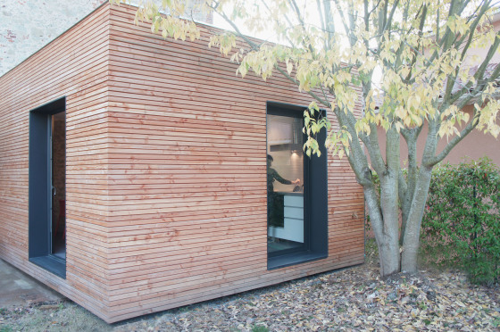 Extension bois pour une maison de ville en pierre grise.