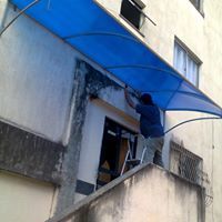 toldo policarbonato azul cobrindo escada e entrada no bloco de condomínio