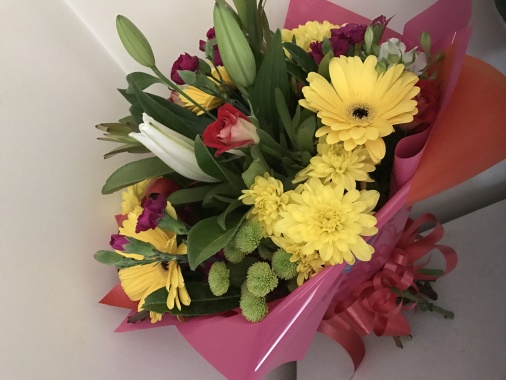Bright bouquet including white lily, yellow and green chrys, roses, gerbs, carnations and mixed seasonal foliages